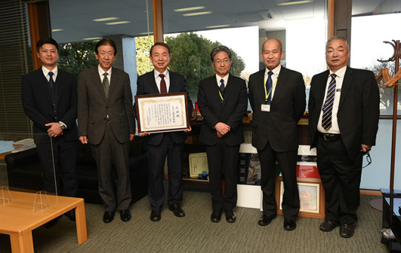 President, Kazumi Komiya of Kanagawa Institute of Technology proudly holding a certificate 